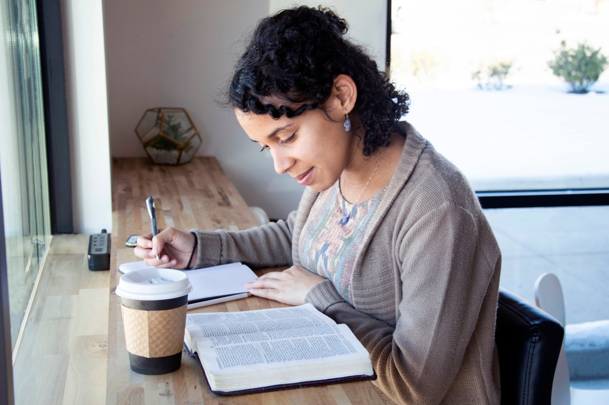 black woman studying Bible in coffee shop